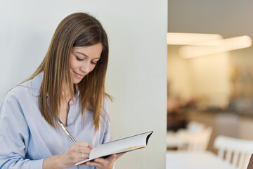 Woman is making notes in cafeteria
