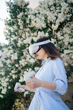 Woman In VR Headset Playing Videogame Outside