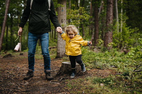 Father exploring forest with daughter on a rainy day