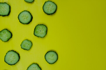 slices of cucumbers on a yellow background