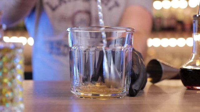 the bartender mixes the sugar from the bottom of a glass