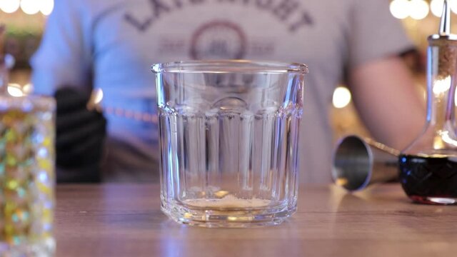 the bartender pours a teaspoon of sugar into the glass