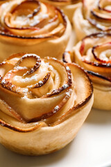 Freshly baked apple roses on light background, closeup. Beautiful dessert