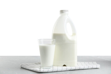 Gallon bottle and glass of milk on light grey table