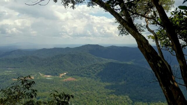 Panorama of tropical rainforest mountains at Gunung Panti, Malaysia. Mountains, peaks, cliffs, rocks, ridges, landscape, green grass, sky, clouds, nature, uncultivated nature, view from mountain peak