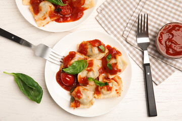 Tasty ravioli with tomato sauce served on white wooden table, flat lay