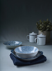 asian Chinese or Japan blue ceramic bowl and plate drawing design with blue cloth and wood board on blue wood table dinnerware