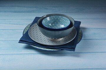 asian Chinese or Japan blue ceramic bowl and plate drawing design with blue cloth and wood board on blue wood table dinnerware