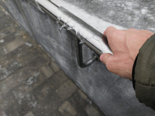 Male hand holding icing frosting handle on city street