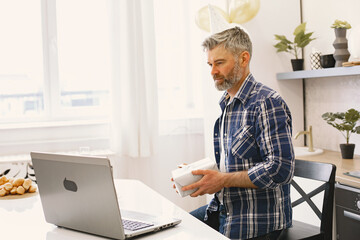 Man is celebrating his birthday with someone on the Skype throught the laptop