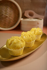 traditional local steam yellow cup cake huat kueh dessert with beautiful display in Pantone color background asian halal dim sum menu