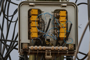 Caja de conectores de señal telefónica e internet con conectores amarillos y cables azules todos enredados  - obrazy, fototapety, plakaty