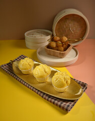 traditional local steam yellow cup cake huat kueh dessert with beautiful display in Pantone color background new asian halal dim sum menu