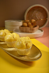 traditional local steam yellow cup cake huat kueh dessert with beautiful display in Pantone color background new asian halal dim sum menu