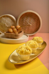 traditional local steam yellow cup cake huat kueh dessert with beautiful display in Pantone color background new asian halal dim sum menu