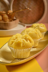 traditional local steam yellow cup cake huat kueh dessert with beautiful display in Pantone color background new asian halal dim sum menu