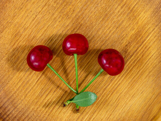 Cherry, red berries on a wooden stand, on the kitchen table, a combination of dessert and still life, close-up, top angle.