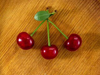 Cherry, red berries on a wooden stand, on the kitchen table, a combination of dessert and still life, close-up, top angle.