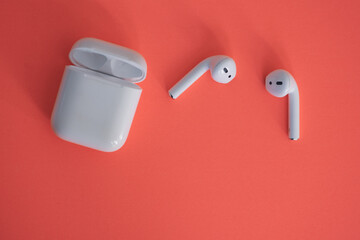 Wireless ear buds isolated against colourful background