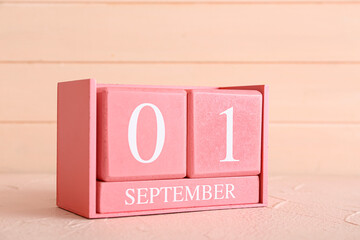 Cube calendar with date SEPTEMBER 1 on color background, closeup