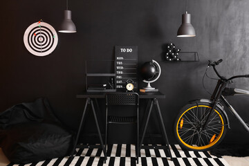 Interior of stylish room with modern workplace and bicycle