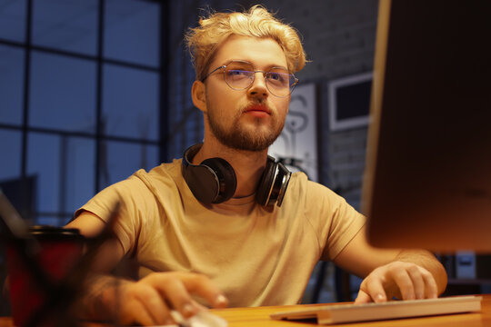 Male programmer working with computer late in evening