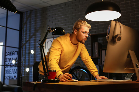 Male programmer working with computer late in evening