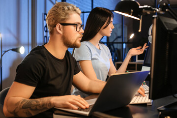 Young programmers working in office at night