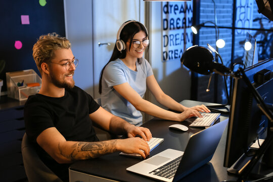 Young programmers working with computer in office at night