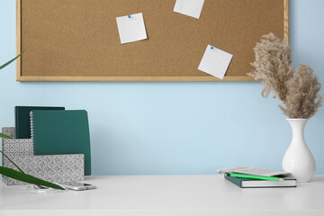 Modern workplace with notebooks near color wall