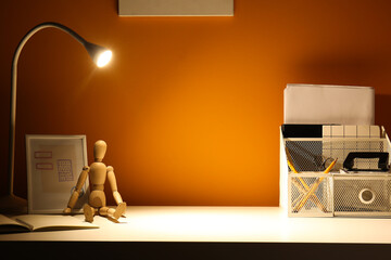 Modern workplace with organizer and glowing lamp in dark room