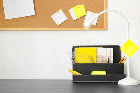 Modern organizer and lamp near light wall