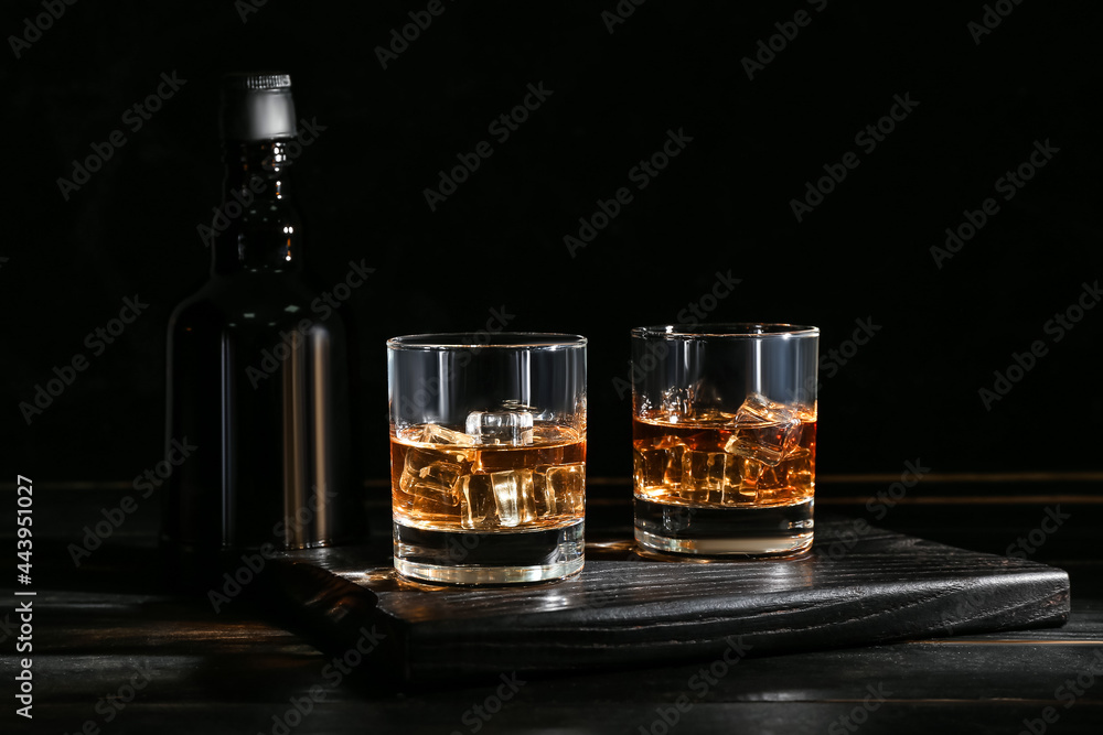 Wall mural bottle and glasses of cold whiskey on dark wooden background