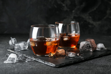 Glasses of cold whiskey on dark background