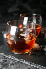 Glasses of cold whiskey on dark background