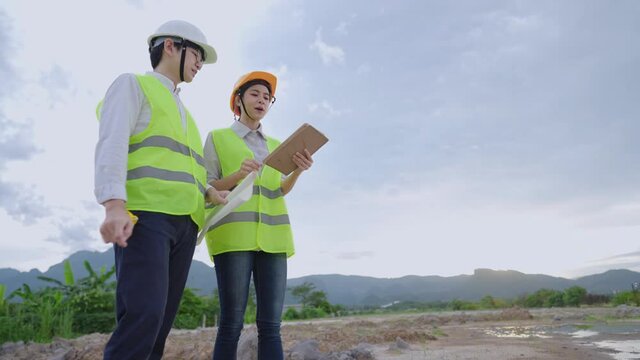 A young on probation trainee learning with explaining to manager a usage of portable work tool at outdoor workshop site, senior and junior workers concept, working environment,  construction industry