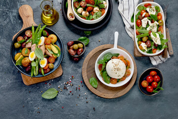 Fototapeta na wymiar Assorted salads on dark gray background. Seasonal food concept.