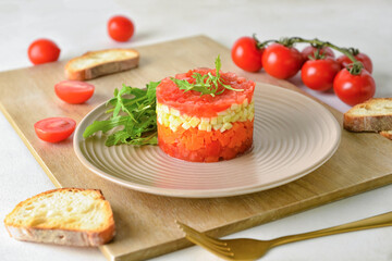 Plate with tasty tartare salad and toasted bread on light background