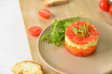 Plate with tasty tartare salad and toasted bread on light background, closeup