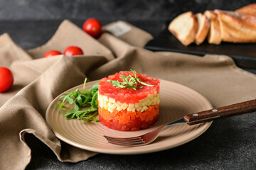 Plate with tasty tartare salad on dark background