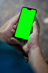 Close-up of a phone with a green screen in male hands. A man holds a smartphone in his hands. Copy space.