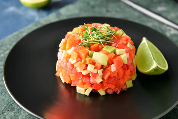 Plate with tasty tartare salad and lime, closeup