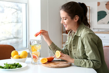 Young woman making fresh lemonade at home - obrazy, fototapety, plakaty