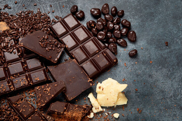 Cacao beans and chocolate on gray background.