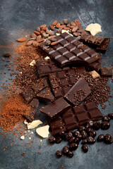 Cacao beans and chocolate on gray background.