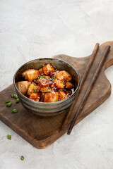 Traditional homemade fried tofu with sesame on light gray background.