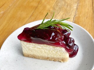 A piece of blueberry cheesecake on the white dish.