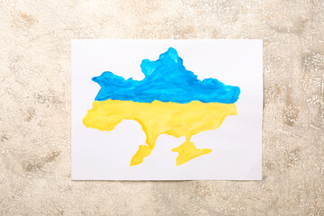 Paper sheet with painting of Ukrainian flag on grunge background