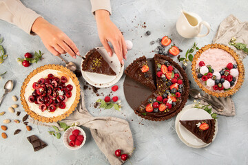 Different types of homemade tarts on light gray background.
