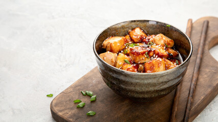 Traditional homemade fried tofu with sesame on light gray background.